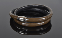 Armbånd i chokoladebrun lak læder og sort kalveskind. 2 omgange med magnetlås i stål. Tykkelse 7,5 mm.